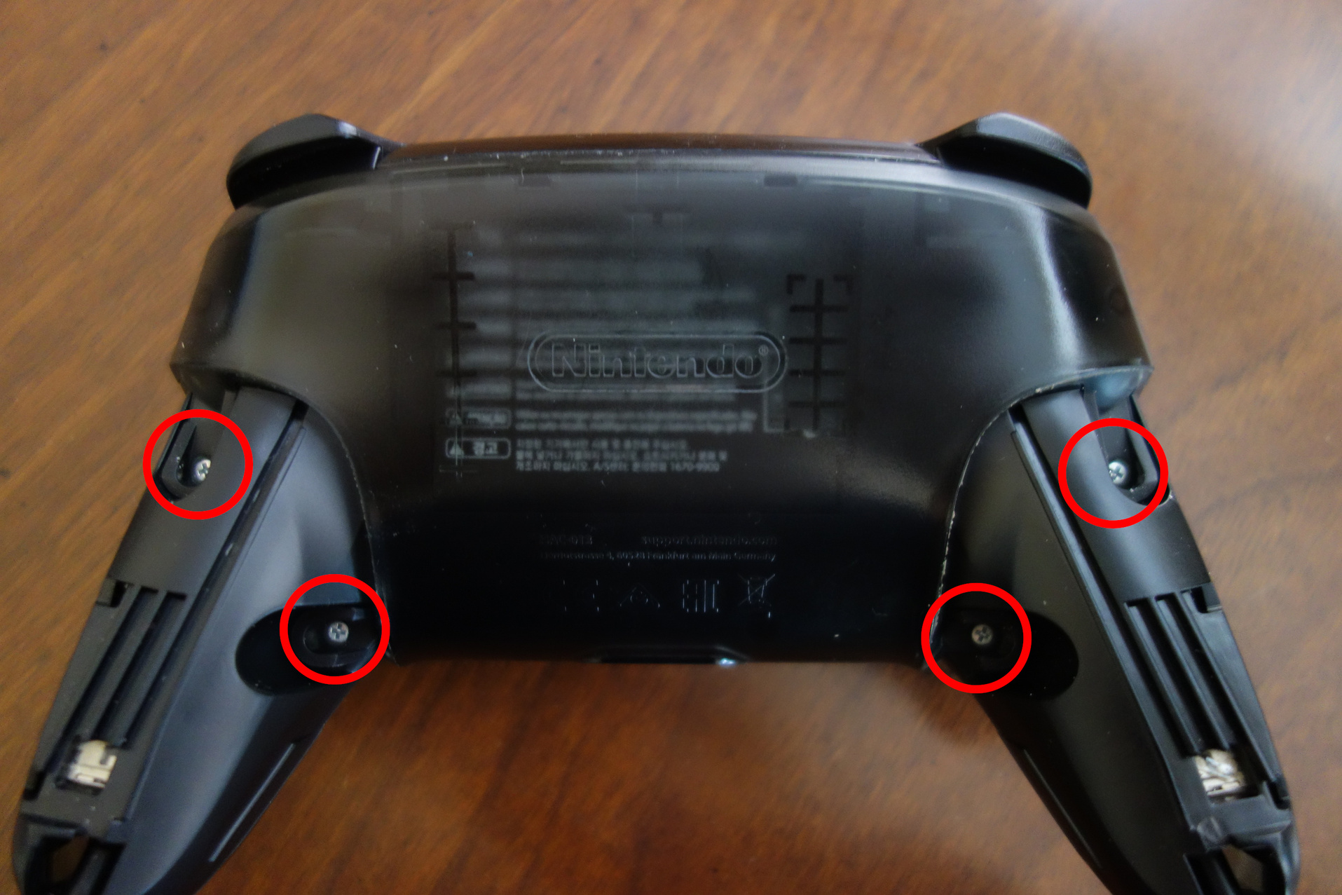 Image of pro controller with grips removed and backplate screws circled