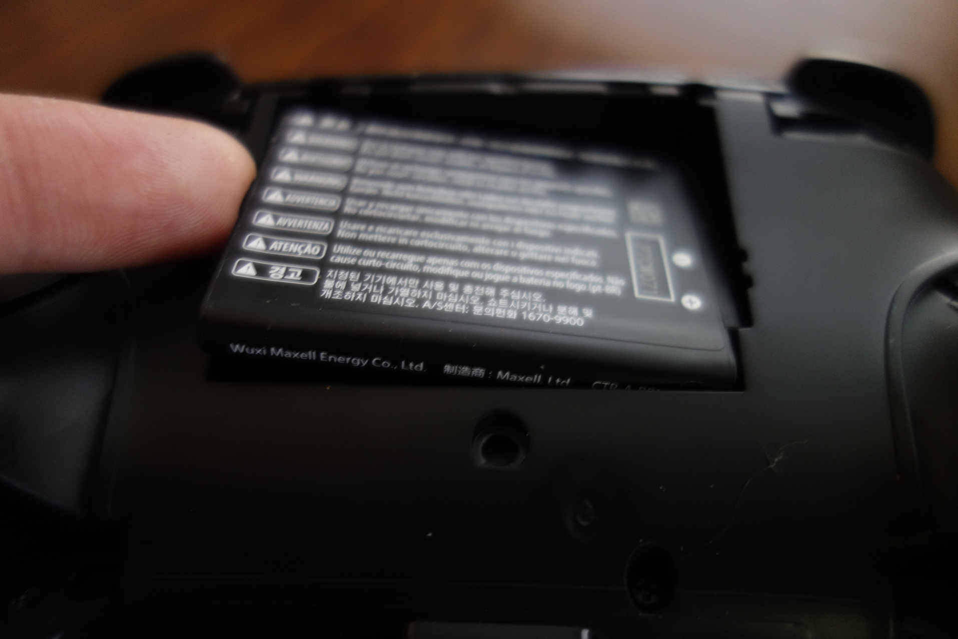 Image of pulling battery out of pro controller with backplate removed